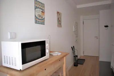 a microwave sitting on top of a wooden table at NEW! Colorful and central (9 min-walk to main station) in Porto