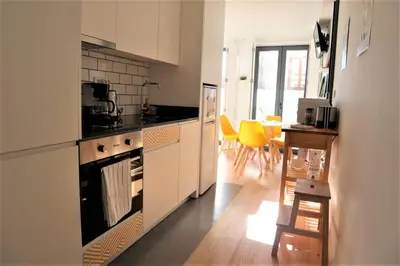 a kitchen with a stove top oven next to a table at NEW! Colorful and central (9 min-walk to main station) in Porto