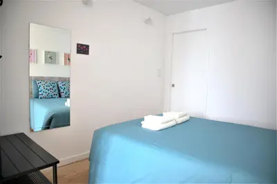 a bedroom with a blue bed and a mirror at NEW! Colorful and central (9 min-walk to main station) in Porto