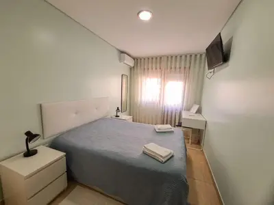 a small bedroom with a bed and a television at Private Room at Fatima's in Porto