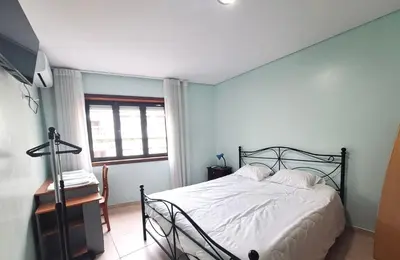 a bedroom with a bed and a desk and a window at Private Room at Fatima's in Porto