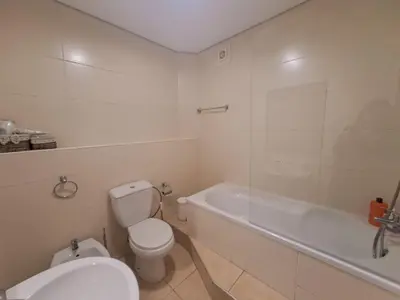 a white bathroom with a toilet and a bath tub at Private Room at Fatima's in Porto