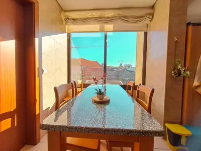 a dining room table with chairs and a large window at Private Room at Fatima's in Porto