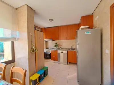 a kitchen with a stainless steel refrigerator and wooden cabinets at Private Room at Fatima's in Porto