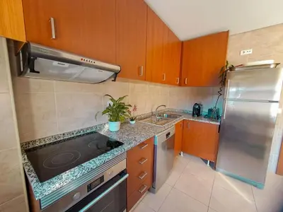 a kitchen with wooden cabinets and a stainless steel refrigerator at Private Room at Fatima's in Porto