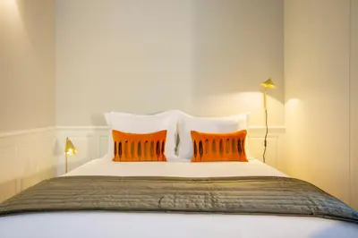 a bed with two orange pillows on top of it at Barão Oporto Apartments in Porto