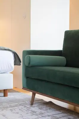 a green couch in a room with a bed at Barão Oporto Apartments in Porto