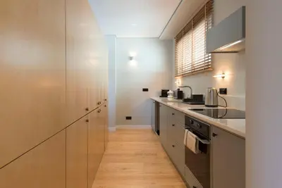 a kitchen with stainless steel appliances and wooden floors at Ceuta 33 Apartment in Porto
