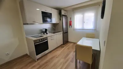 a kitchen with white cabinets and a table and a window at Marques Garden with PARKING in Porto