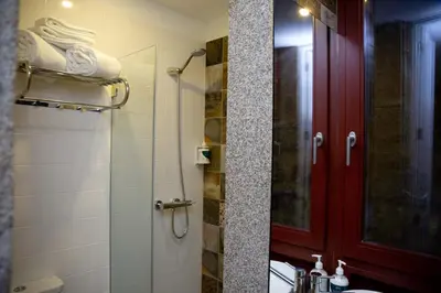 a bathroom with a shower and a red door at Oporto Ana's Studio in Porto