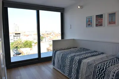 a kitchen with white cabinets and a white refrigerator at Sunny Penthouse whith balcony 9min walk main station in Porto