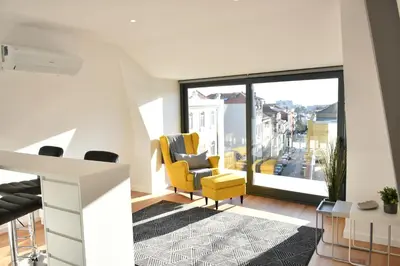 a staircase in a house with a glass railing at Sunny Penthouse whith balcony 9min walk main station in Porto