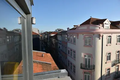 a hallway with white walls and wood floors at Sunny Penthouse whith balcony 9min walk main station in Porto
