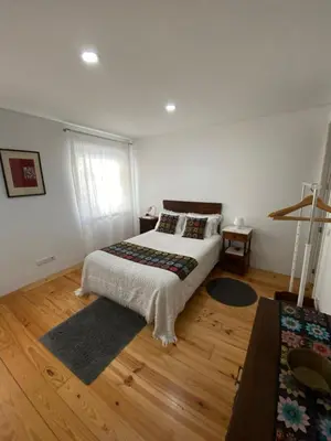 a bedroom with a bed on a wooden floor at Casa 45 Porto in Porto