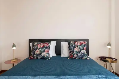 a bed with a blue comforter and two pillows at LovelyStay - Homey Feeling Flat w/ Free Parking in Porto