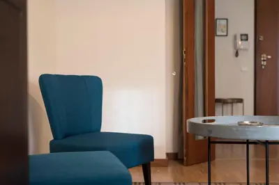 a blue chair and a table in a room at LovelyStay - Homey Feeling Flat w/ Free Parking in Porto