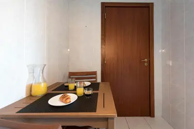 a table with a plate of food and two glasses of orange juice at LovelyStay - Homey Feeling Flat w/ Free Parking in Porto