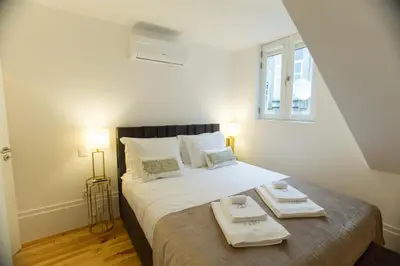 a bedroom with a bed with two trays on it at Loft da Sé by Porto City Hosts in Porto