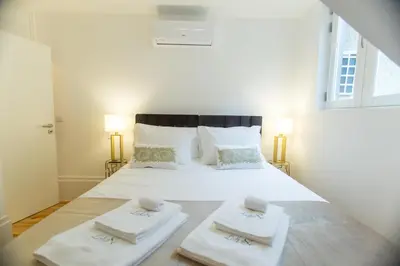 a bedroom with a white bed with two towels on it at Loft da Sé by Porto City Hosts in Porto