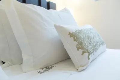 a pile of white pillows on a bed at Loft da Sé by Porto City Hosts in Porto