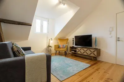 a living room with a couch and a tv at Loft da Sé by Porto City Hosts in Porto