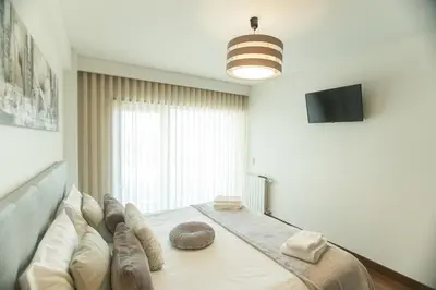 a bedroom with a large bed with a large window at Afurada premium apartment by Porto City Hosts in Vila Nova de Gaia