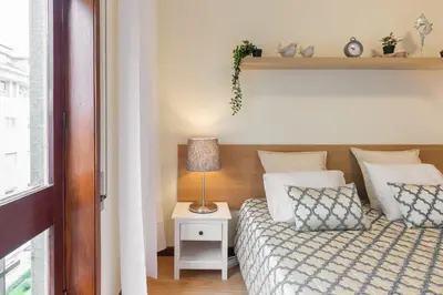 a bedroom with a bed and a lamp on a night stand at Host Wise - Deluxe Bright Flat with Netflix in Porto