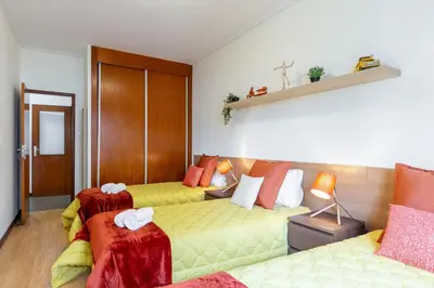 a room with two beds with yellow cushions at Host Wise - Deluxe Bright Flat with Netflix in Porto