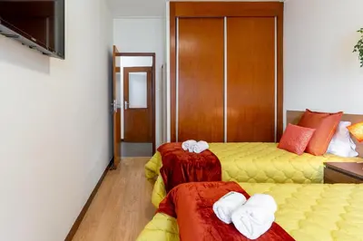 a hotel room with two beds with towels at Host Wise - Deluxe Bright Flat with Netflix in Porto