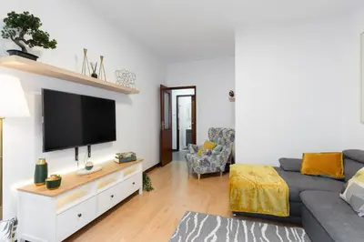 a living room with a couch and a flat screen tv at Host Wise - Deluxe Bright Flat with Netflix in Porto