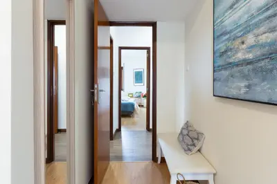 a hallway leading to a living room with a painting on the wall at Host Wise - Deluxe Bright Flat with Netflix in Porto