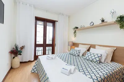 a bedroom with a bed with towels on it at Host Wise - Deluxe Bright Flat with Netflix in Porto
