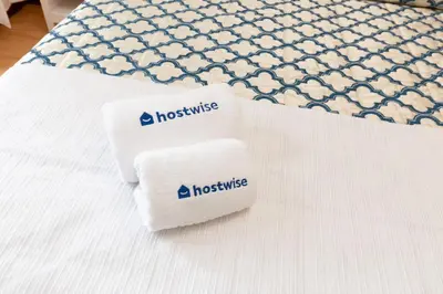 two towels sitting on top of a bed at Host Wise - Deluxe Bright Flat with Netflix in Porto
