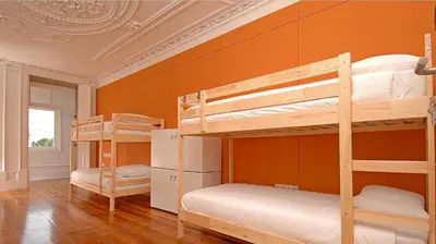 two bunk beds in a room with an orange wall at So Cool Hostel Porto in Porto