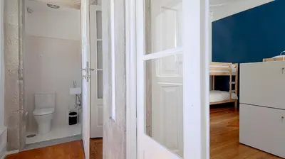 a bathroom with a toilet and a room with a door at So Cool Hostel Porto in Porto