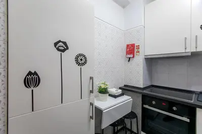 a small kitchen with white cabinets and a counter at Casa da Alegria- Downtown by Oporto Soul in Porto