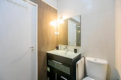 a bathroom with a toilet and a sink and a mirror at Casa da Alegria- Downtown by Oporto Soul in Porto