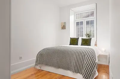 a white bedroom with a bed and a window at Oporto Classic Pàtio in Porto
