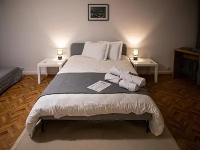 a bedroom with a large bed with two tables at Silva's Guest House in Vila Nova de Gaia