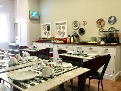 a dining room with tables and chairs with plates on them at B The Guest Downtown in Porto