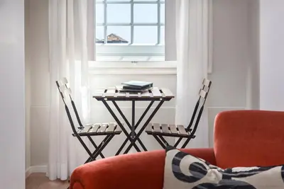 a table and chairs in a living room with a window at B The Guest Downtown in Porto