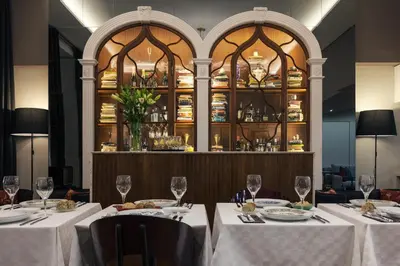 a dining room with two tables with white tablecloths at B The Guest Downtown in Porto