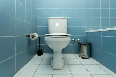 a bathroom with a toilet in a blue tiled room at Porto by the River 1 in Porto