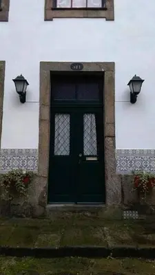 a green door on a white building with two lights at Cosy apartment in Porto city centre – 50 sqm with parking in Porto