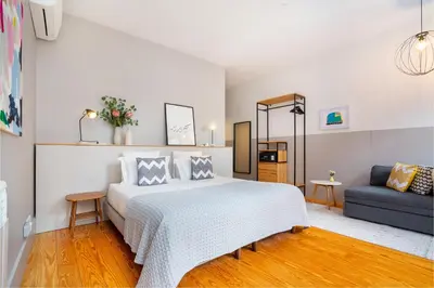 a bedroom with a white bed and a couch at Luxury Old Town Oasis for Family and Friends (Daily Breakfast + Housekeeping incl) in Porto