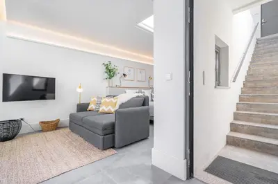 a living room with a couch and a tv at Luxury Old Town Oasis for Family and Friends (Daily Breakfast + Housekeeping incl) in Porto
