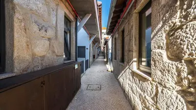 a narrow alleyway between two buildings with windows at CASA DOURO Porto City in Porto