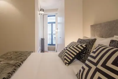 a bedroom with a white bed with pillows on it at Tailor's Apartment in Porto