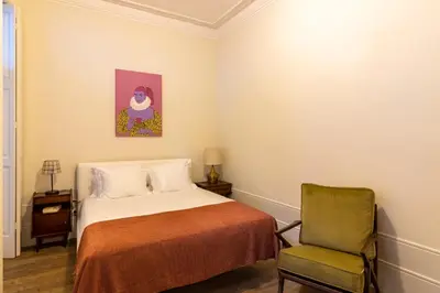 a bedroom with a bed and a chair at aDuquesa - GuestHouse in Porto