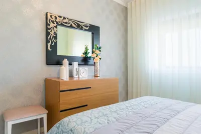 a bedroom with a bed and a dresser with a mirror at Metropolitan Gaia-Porto in Vila Nova de Gaia